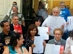 Algunos asistentes exhiben los legajos de sus familiares.