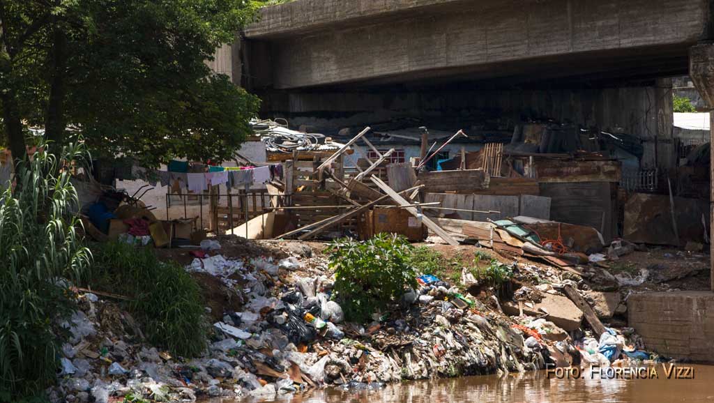 Entre la basura y el hedor constante, a la vera del abandono, alguien tiende al sol su ropa limpia, como la última bandera en resguardo de la dignidad…