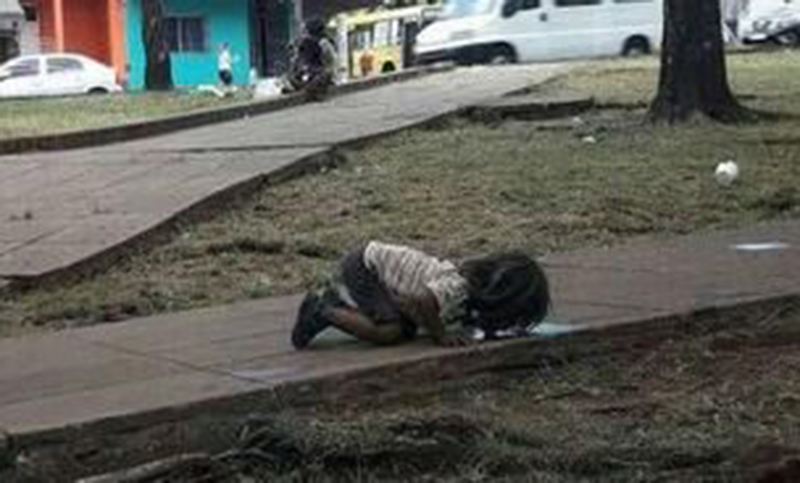 Estremecedora foto de una niña tomando agua de un charco